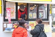 注文を受けるキッチンカーの男性定員