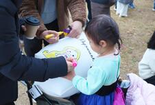 ランタンに絵を描く女性とそれを見る女の子