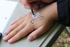 ボディーペイントを描いてもらっている男の子の手元