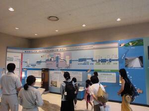 北千葉浄水場の施設内ホールで北千葉広域水道企業団の説明員から説明を受けている様子