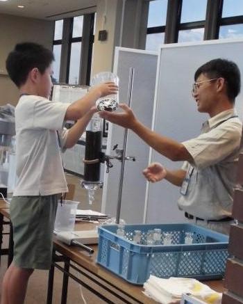 ろ過機に水を入れて水をきれいにするための実験を行う様子
